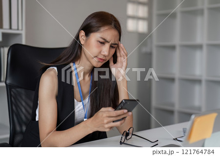 Exhausted Young Female Office Worker Struggling with Fatigue at Her Desk in a Modern Workplace Setting Exhausted Young Female Office Worker Struggling with Fatigue at Her Desk in a Modern Workplace Setting 121764784