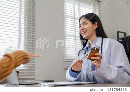 Female Doctor Offering Health Advice and Medicine Guidance in a Modern Medical Office Setting Female Doctor Offering Health Advice and Medicine Guidance in a Modern Medical Office Setting 121764858