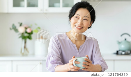 Serene morning scene with asian female enjoying tea in modern kitchen 121764859