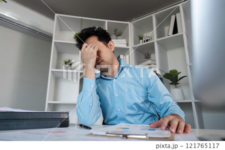 Tired business professional struggling with hard work in office environment captured moment of exhaustion Tired business professional struggling with hard work in office environment captured moment of exhaustion 121765117
