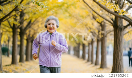 Elderly asian female enjoying autumn jogging in park for fitness and wellbeing 121765262