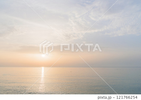 Sunrise at the sea beach. Calm sea without waves in the morning. 121766254