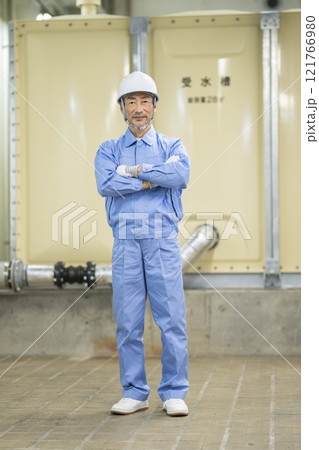 カメラ目線で腕組みをした作業服姿のシニア男性　ビルメンテナンススタッフ　イメージ　 121766980