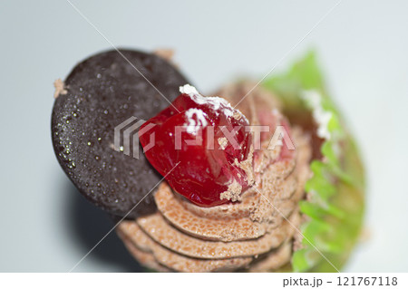 Sweet cake with cream and chocolate , and a cookie , on the table 121767118