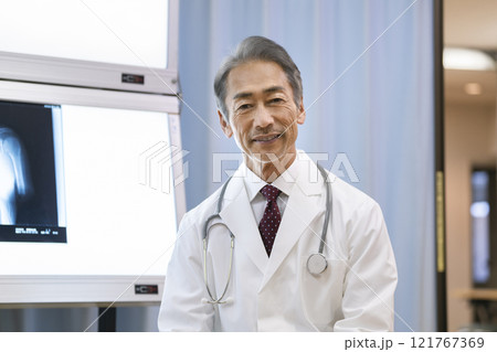 カメラ目線で話すベテランの男性医師 カメラ目線で話すベテランの男性医師 121767369