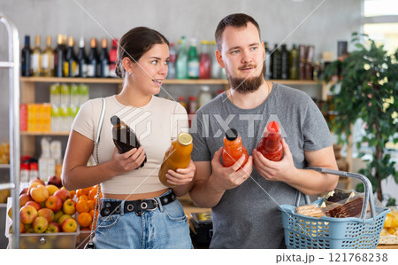 Couple choosing juices in the supermarket Couple choosing juices in the supermarket 121768238