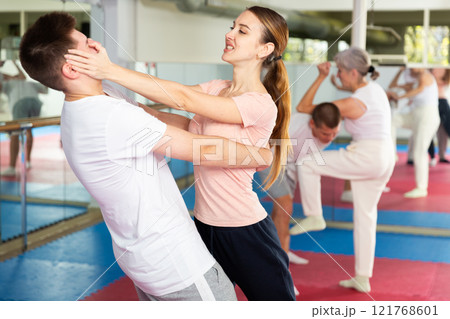 Girl using painful technique for eyes to opponent in self-defense training Girl using painful technique for eyes to opponent in self-defense training 121768601