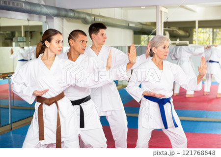 Karate or taekwondo training - athletes in kimono stand in fighting stance 121768648
