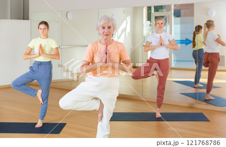 Group of women exercising during yoga class 121768786
