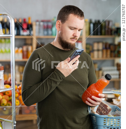 Man purchaser scanning QR code or barcode of bottle grapefruit in supermarket 121768787