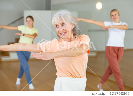 Mature female dancing with other women 121768863