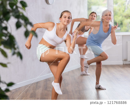 Teenage girl dancing in group in studio Teenage girl dancing in group in studio 121768886