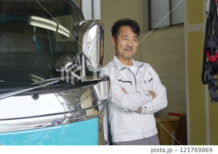 トラックの横に立つ作業服を着た男性のポートレート トラックの横に立つ作業服を着た男性のポートレート 121769869