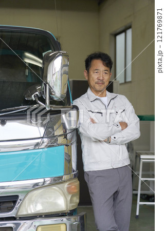 トラックの横に立つ作業服を着た男性のポートレート 121769871