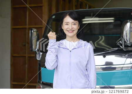 トラックの前でガッツポーズをする女性 121769872