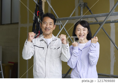 ガッツポーズする作業員の夫婦 121769880