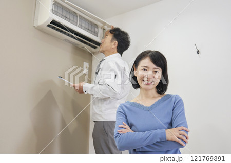 エアコンの故障の修理に安心する女性 121769891
