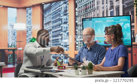 Senior clients asking a financial advisor about various retirement options, protecting their life savings and pension for future stability. Counseling to increase their income. Camera B. Senior clients asking a financial advisor about various retirement options, protecting their life savings and pension for future stability. Counseling to increase their income. Camera B. 121770295