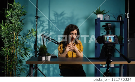Content creator using professional camera to shoot intro for vlog channel on online platforms. Internet star warmly welcoming dedicated fanbase, recording with advanced gear, camera B Content creator using professional camera to shoot intro for vlog channel on online platforms. Internet star warmly welcoming dedicated fanbase, recording with advanced gear, camera B 121770324