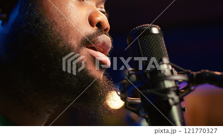 Artist records his voice on microphone in home studio singing a song composed by him. Skilled musician using recordings and lyrics to edit in post production, mixing and mastering session. Camera A. Artist records his voice on microphone in home studio singing a song composed by him. Skilled musician using recordings and lyrics to edit in post production, mixing and mastering session. Camera A. 121770327