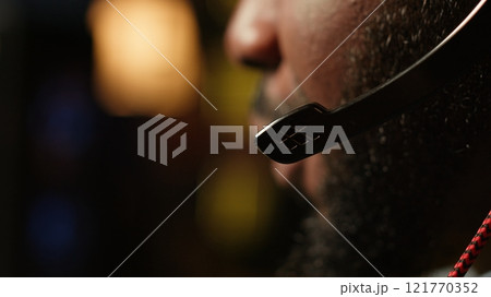 Man having fun playing videogames on PC while chatting with teammates through headphones mic. Close up of gamer battling rival players, communicating with friends through headset microphone, camera A Man having fun playing videogames on PC while chatting with teammates through headphones mic. Close up of gamer battling rival players, communicating with friends through headset microphone, camera A 121770352