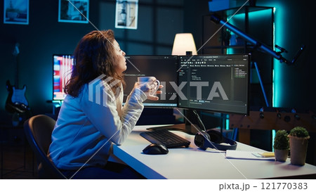 Portrait of engineer drinking coffee in the morning and futureproofing company network from downtimes. IT admin enjoying hot beverage while increasing data security, camera B 121770383