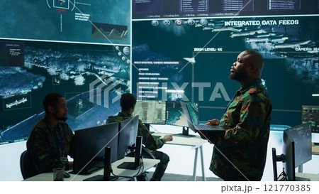 Military specialists work in a high tech command post center, focusing on cybersecurity, surveillance and data protection to ensure the security and integrity of national information. Camera B. Military specialists work in a high tech command post center, focusing on cybersecurity, surveillance and data protection to ensure the security and integrity of national information. Camera B. 121770385