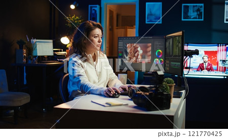 Video editor selecting key frames to use while doing video montage, working from home on computer. Cheerful woman using mouse to edit movie project footage in office, camera B Video editor selecting key frames to use while doing video montage, working from home on computer. Cheerful woman using mouse to edit movie project footage in office, camera B 121770425