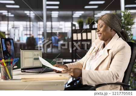 Businesswoman holding teleconference meeting with HR, liaising to recruit, train and guide staff. Team leader instructing human resources worker in online remote videocall using tablet 121770501