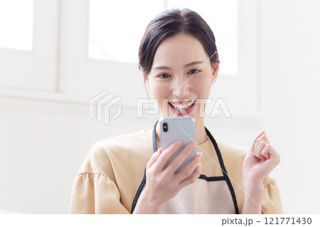 スマホを見る主婦の女性 121771430