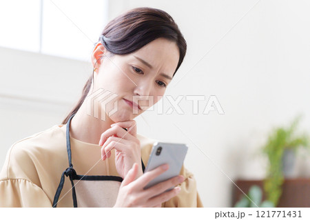 スマホを見る主婦の女性 121771431