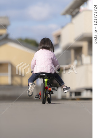 自転車練習を頑張る幼い女の子の後ろ姿 121771724