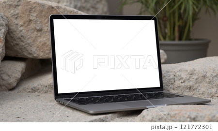 Mockup laptop. Outdoor workspace with laptop on rocks, blank screen, natural setting, remote work, portable computer, modern technology, nature background, creative environment 121772301