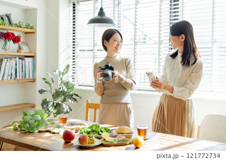 食卓の料理写真を撮る女性 食卓の料理写真を撮る女性 121772734
