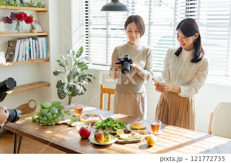 食卓の料理写真を撮る女性 食卓の料理写真を撮る女性 121772735