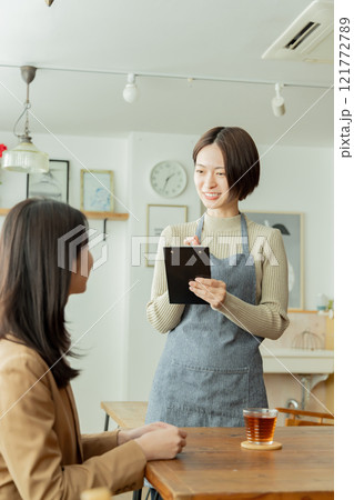 カフェでオーダーを聞く女性スタッフ 121772789