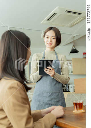 カフェでオーダーを聞く女性スタッフ 121772791