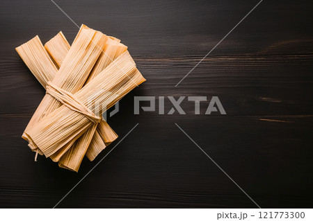 Close-up of steaming tamales encased in banana leaves, a classic Mexican dish 121773300