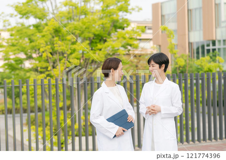 笑顔で話す白衣の女性達 笑顔で話す白衣の女性達 121774396