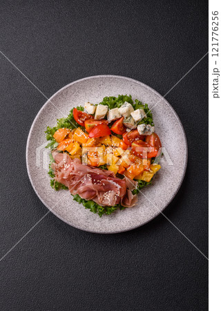 Appetizing salad with prosciutto, pumpkin, cheese and tomatoes Appetizing salad with prosciutto, pumpkin, cheese and tomatoes 121776256