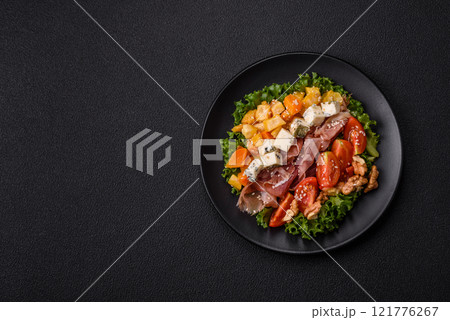 Appetizing salad with prosciutto, pumpkin, cheese and tomatoes 121776267
