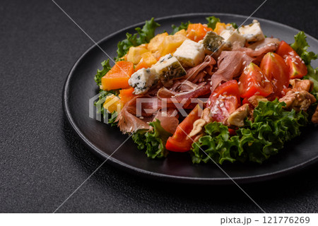 Appetizing salad with prosciutto, pumpkin, cheese and tomatoes 121776269