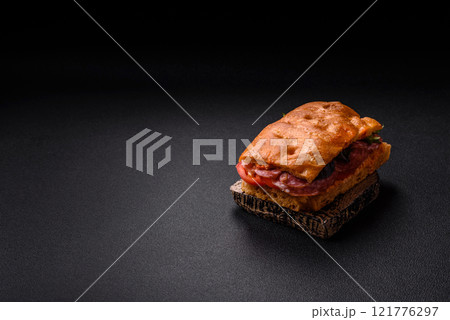 Focaccia with salami, cheese, tomatoes, arugula, salt, spices and herbs 121776297