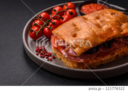 Focaccia with salami, cheese, tomatoes, arugula, salt, spices and herbs 121776322