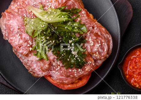 Focaccia with salami, cheese, tomatoes, arugula, salt, spices and herbs Focaccia with salami, cheese, tomatoes, arugula, salt, spices and herbs 121776338