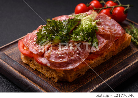 Focaccia with salami, cheese, tomatoes, arugula, salt, spices and herbs 121776346