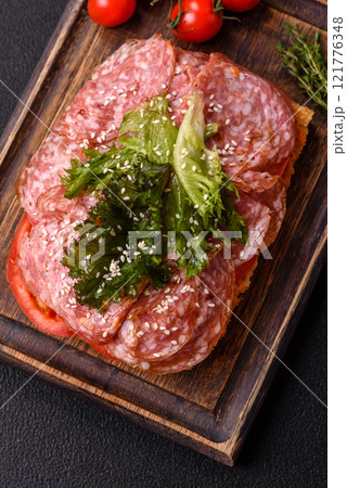 Focaccia with salami, cheese, tomatoes, arugula, salt, spices and herbs Focaccia with salami, cheese, tomatoes, arugula, salt, spices and herbs 121776348