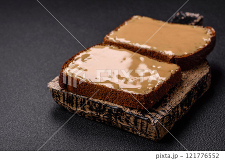 Sandwiches with toast bread, peanut butter and raspberry or strawberry jam 121776552