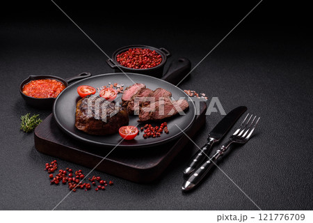Juicy beef steak baked on the grill with salt, spices and herbs Juicy beef steak baked on the grill with salt, spices and herbs 121776709