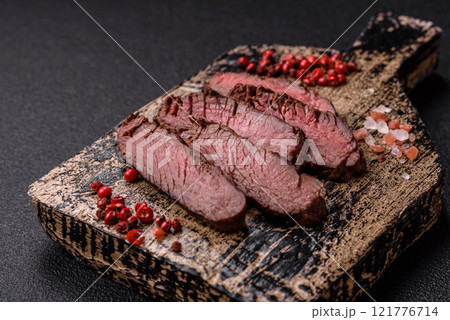 Juicy beef steak baked on the grill with salt, spices and herbs Juicy beef steak baked on the grill with salt, spices and herbs 121776714
